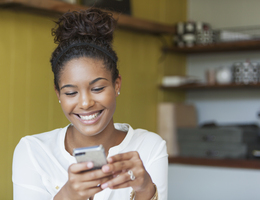 A girl smiling at her phone.