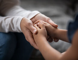  Adult holding a child's hands.