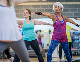 An older woman exercising in an aerobics class.