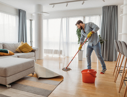 A man mopping a wood floor.