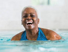 A laughing woman standing in a pool. 