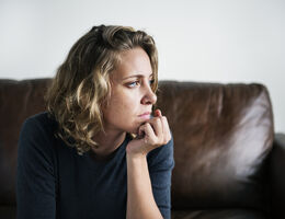  Pensive woman on a couch.