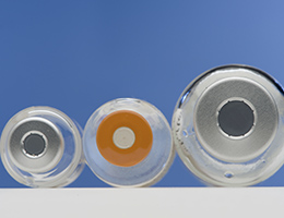 Insulin vials in three sizes with caps facing out with a blue backdrop.
