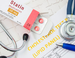An open box of statin medication, alongside a stethoscope, a pen and printouts of lab test results.