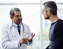 A man and a doctor talking in an office setting.