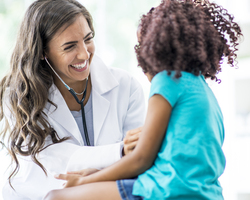 A doctor listens to a child’s heart