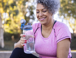 A woman holds a reusable water bottle