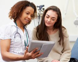 A woman and her doctor look at a tablet display