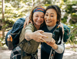 Two women in hiking gear take a selfie.