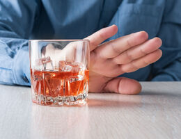  A hand pushes a glass away