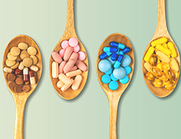 A variety of pills in wooden spoons. 