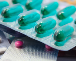 Three kinds of pills in foil and plastic blister packs.