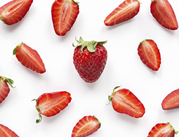 A group of strawberries, cut and whole.