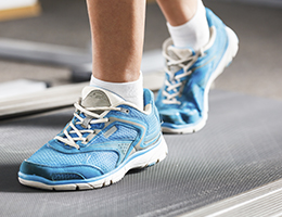 Closeup of blue shoes walking on a treadmill. 