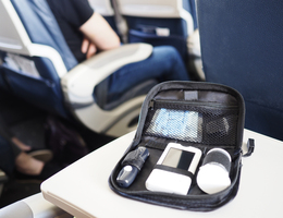 A kit of diabetes supplies on the seat-back table of an airplane
