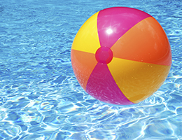 A beach ball floating in a pool. 