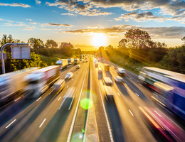 Blurred cars speed down a highway.